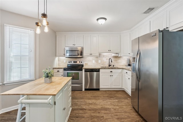 7117 Deer Thicket Dr, Midlothian, VA 23112 - kitchen featuring stainless steel appliances, white cabinetry, butcher block countertops, and decorative backsplash
