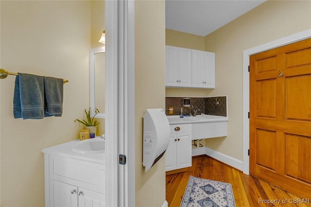 744 Possum Point Rd, Port Haywood, VA 23109 - bathroom with wood finished floors, decorative backsplash, and vanity