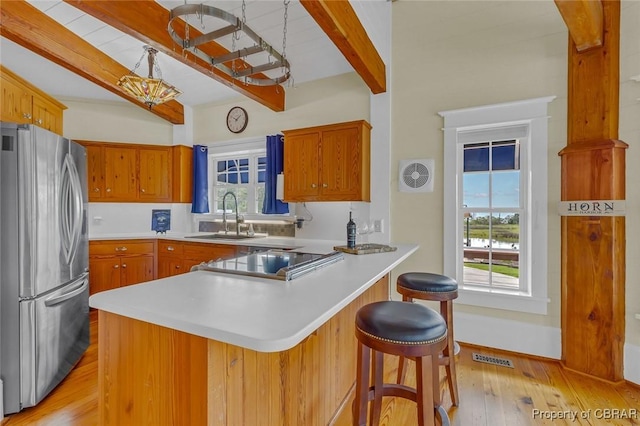 744 Possum Point Rd, Port Haywood, VA 23109 - kitchen with beam ceiling, freestanding refrigerator, a peninsula, light wood finished floors, and light countertops