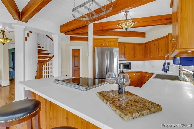 744 Possum Point Rd, Port Haywood, VA 23109 - kitchen with freestanding refrigerator, light countertops, stovetop, and brown cabinets