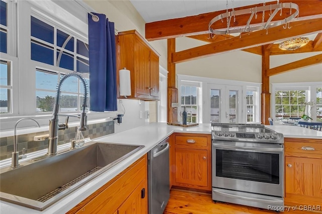 744 Possum Point Rd, Port Haywood, VA 23109 - kitchen featuring stainless steel appliances, brown cabinetry, a peninsula, and light countertops