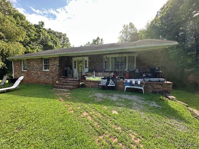 4232 Three Bridge Rd, Powhatan, VA 23139 - rear view of house with brick siding, a lawn, a chimney, outdoor lounge area, and a porch