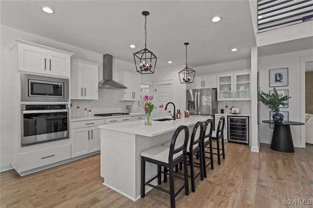 9255 Saxsawn Ln, Chesterfield, VA 23832 - kitchen featuring appliances with stainless steel finishes, tasteful backsplash, a breakfast bar area, wall chimney range hood, and light countertops