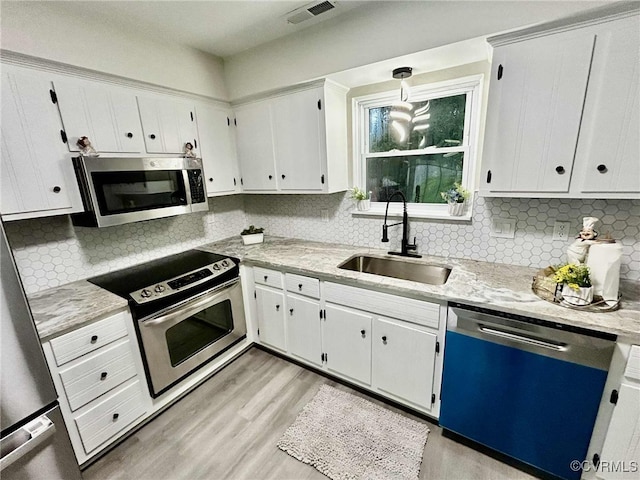 8512 Scottingham Ct, Chesterfield, VA 23236 - kitchen with appliances with stainless steel finishes, light wood-type flooring, decorative backsplash, and white cabinets