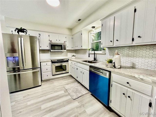8512 Scottingham Ct, Chesterfield, VA 23236 - kitchen featuring stainless steel appliances, light wood-style floors, tasteful backsplash, white cabinetry, and light stone countertops