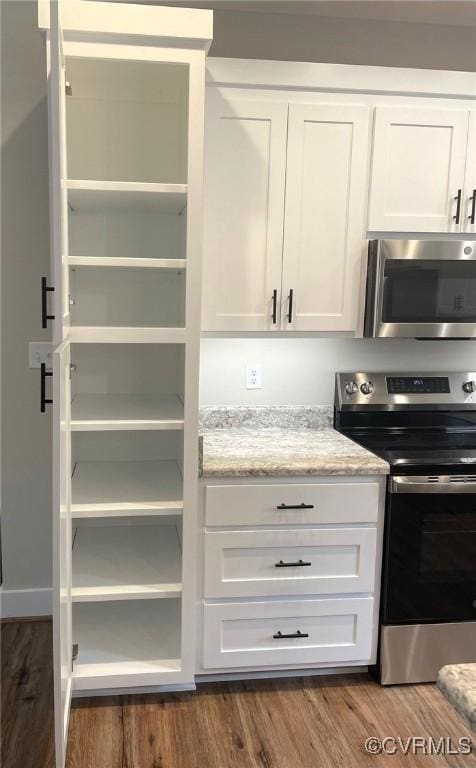 5731 Beechnut Ave, South Chesterfield, VA 23803 - kitchen featuring appliances with stainless steel finishes, white cabinetry, dark wood-type flooring, and light stone counters