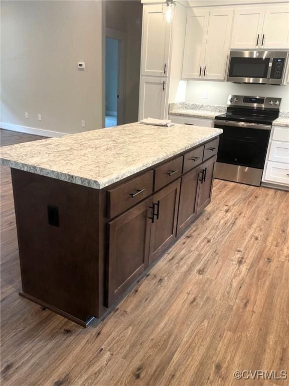 5731 Beechnut Ave, South Chesterfield, VA 23803 - kitchen with stainless steel appliances, light wood-type flooring, white cabinetry, and dark brown cabinetry