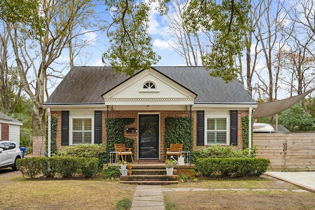 38 Colleton Dr, Charleston, SC 29407 - view of front facade with brick siding, a shingled roof, a porch, and a carport