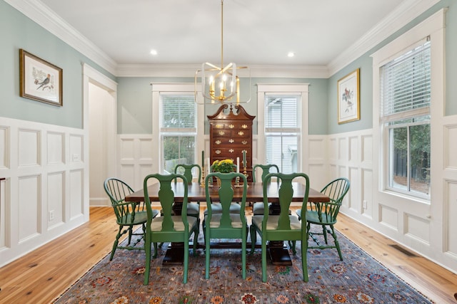 dining area featuring ornamental molding, wood-type flooring, and a chandelier