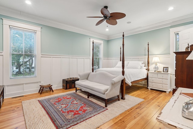 bedroom with ornamental molding, ceiling fan, and light hardwood / wood-style floors