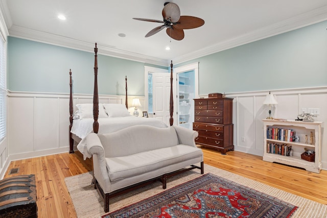 bedroom with ornamental molding, ceiling fan, and light wood-type flooring