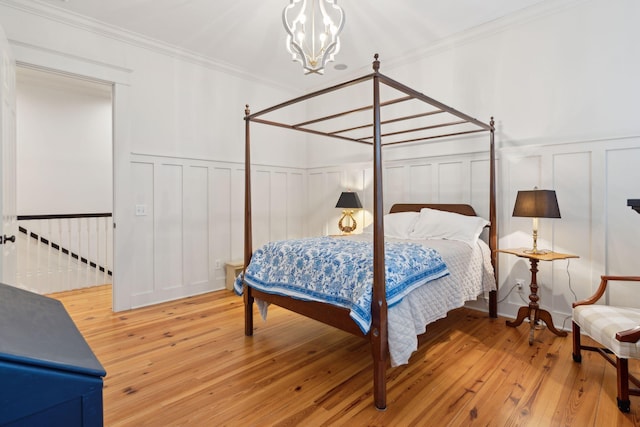 bedroom featuring ornamental molding, hardwood / wood-style floors, and a notable chandelier