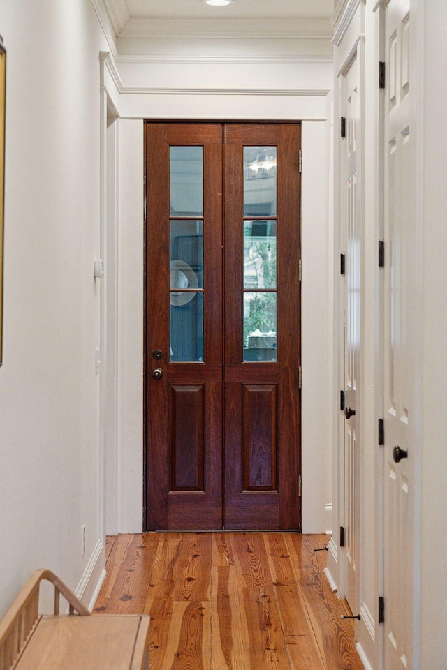 entryway with crown molding and light hardwood / wood-style flooring