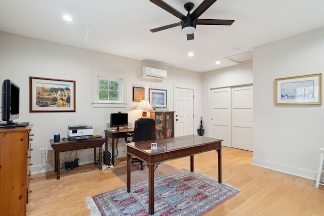 home office featuring ceiling fan, a wall mounted AC, and light wood-type flooring