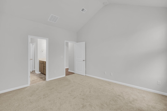 unfurnished bedroom featuring baseboards, light carpet, visible vents, and high vaulted ceiling