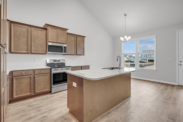 kitchen featuring light wood finished floors, an inviting chandelier, appliances with stainless steel finishes, and a sink
