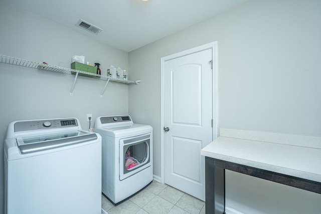 clothes washing area with separate washer and dryer and light tile patterned floors