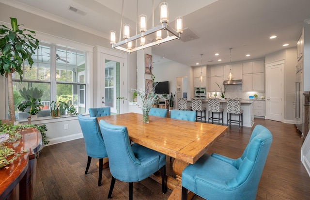 dining area with dark hardwood / wood-style floors and an inviting chandelier