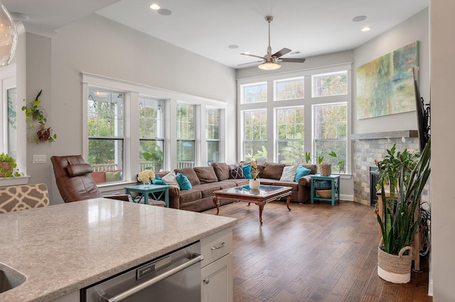 sunroom / solarium featuring a brick fireplace and ceiling fan