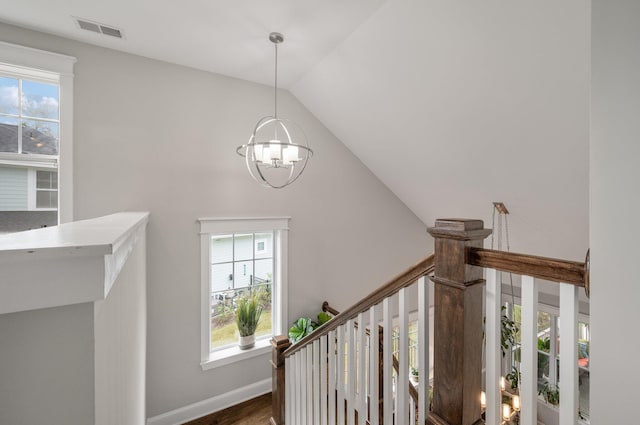 stairs featuring lofted ceiling and an inviting chandelier