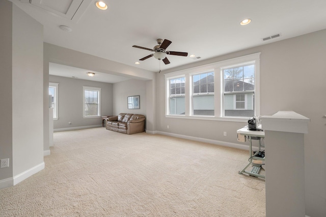 living area featuring light carpet and ceiling fan