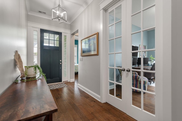 entryway featuring crown molding, dark hardwood / wood-style floors, an inviting chandelier, and french doors