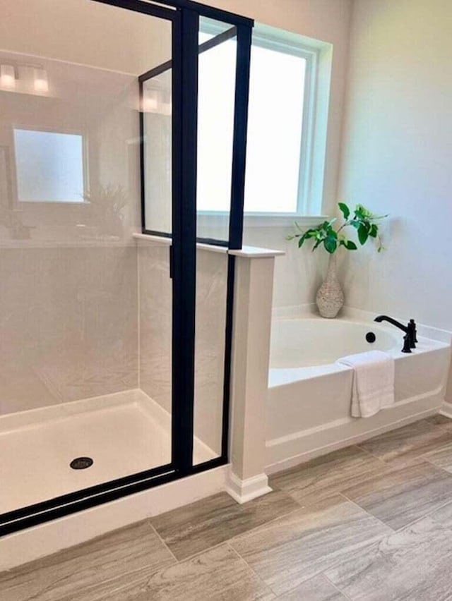 full bathroom featuring a stall shower and a garden tub