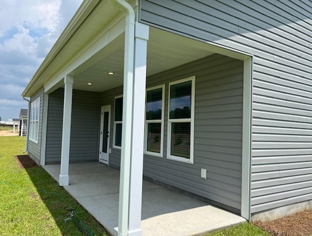 view of side of home with a patio area and a yard