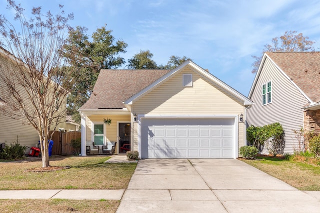 view of front of home with fence, driveway, roof with shingles, an attached garage, and a front lawn