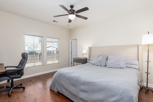 bedroom featuring visible vents, baseboards, dark wood finished floors, and a ceiling fan