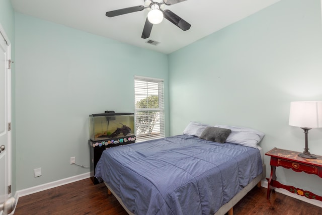 bedroom featuring ceiling fan, wood finished floors, visible vents, and baseboards