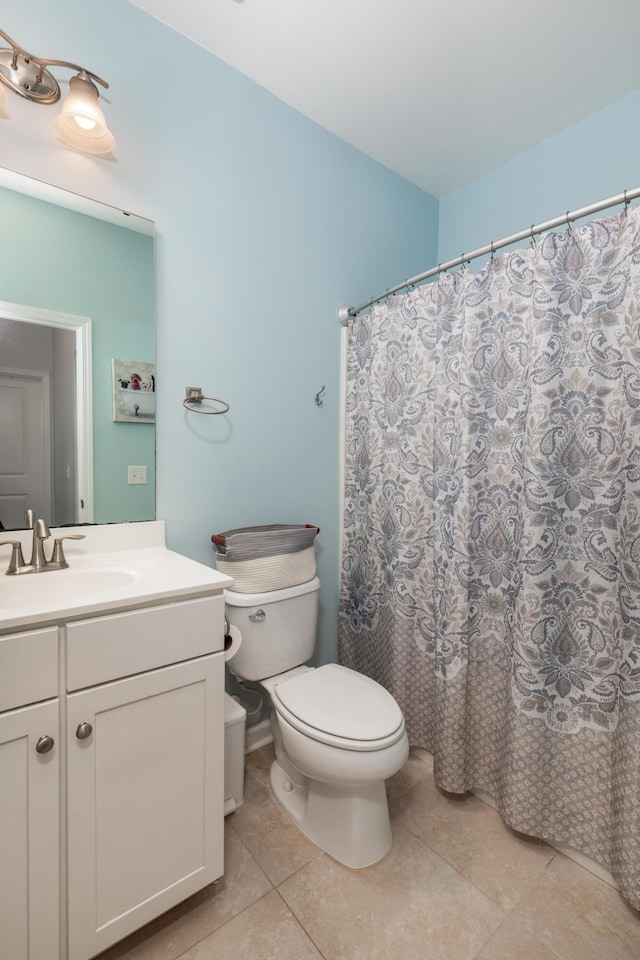 bathroom with tile patterned floors, curtained shower, toilet, and vanity