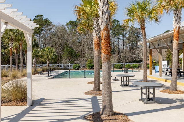 surrounding community with a pool, a patio area, and fence