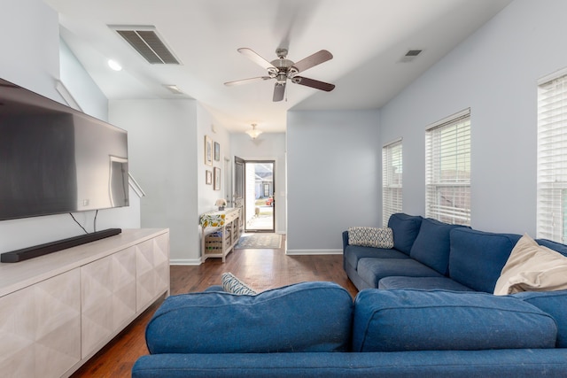 living area with a wealth of natural light, visible vents, and dark wood-style floors