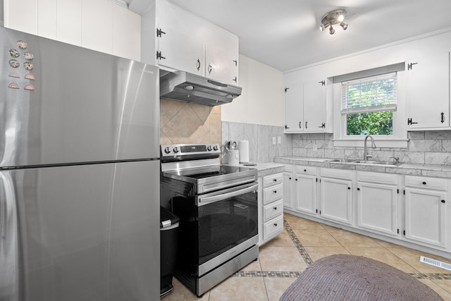 4932 N Rhett Ave, North Charleston, SC 29405 - kitchen with appliances with stainless steel finishes, under cabinet range hood, a sink, light tile patterned flooring, and light countertops