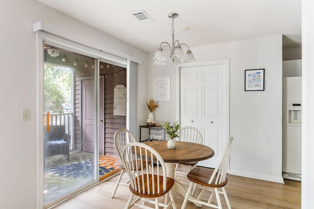 7935 Parklane Ct Unit A, North Charleston, SC 29418 - dining room featuring light wood-type flooring, a chandelier, baseboards, and a textured ceiling