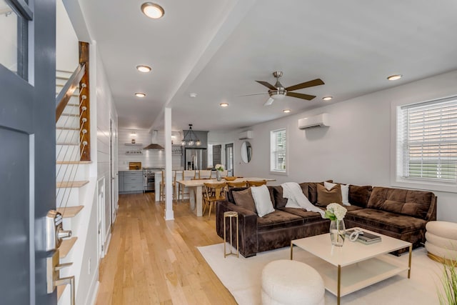 living area with light wood-type flooring, an AC wall unit, and recessed lighting