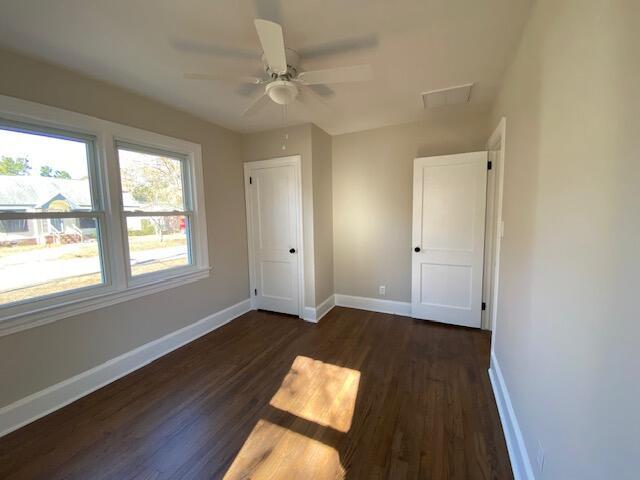 unfurnished bedroom featuring dark wood-type flooring and ceiling fan