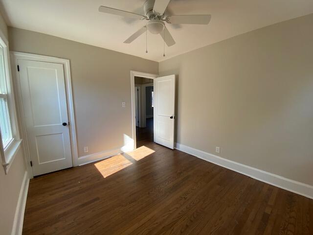 unfurnished bedroom featuring dark wood-type flooring and ceiling fan