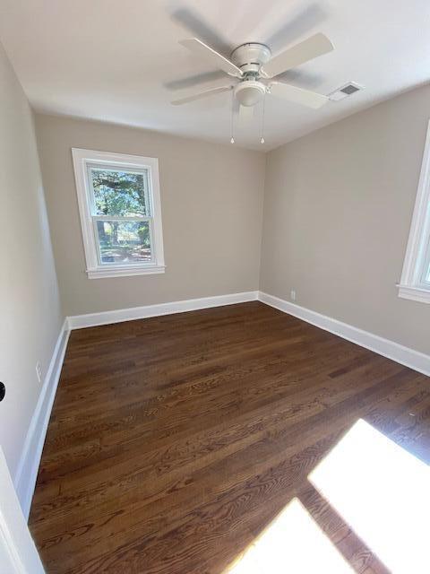 unfurnished room with dark wood-type flooring and ceiling fan