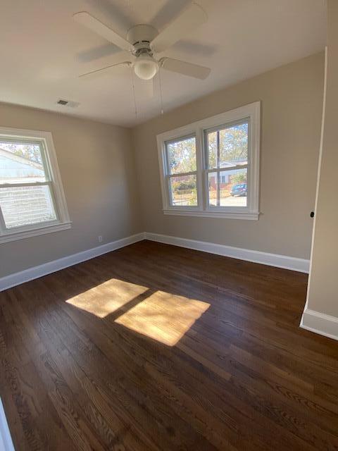 unfurnished room with dark wood-type flooring and ceiling fan