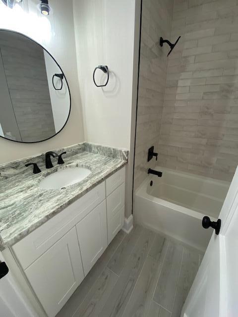 bathroom with vanity and tiled shower / bath