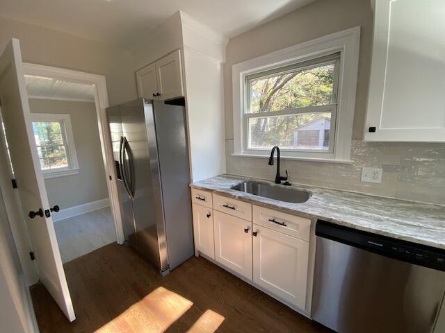 kitchen featuring sink, white cabinets, dark hardwood / wood-style flooring, light stone counters, and stainless steel appliances