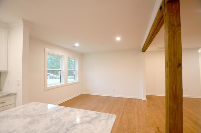 interior space featuring white cabinetry, light stone counters, and light hardwood / wood-style flooring