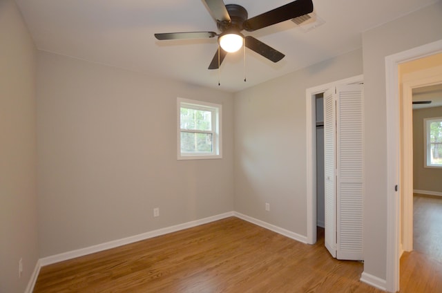 unfurnished bedroom with multiple windows, a closet, and light hardwood / wood-style flooring