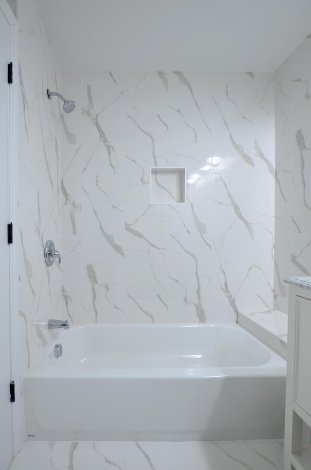 bathroom featuring tiled shower / bath and vanity