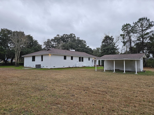 rear view of house with a yard and central AC