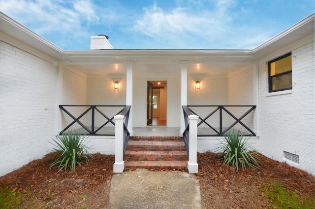 view of exterior entry with a porch