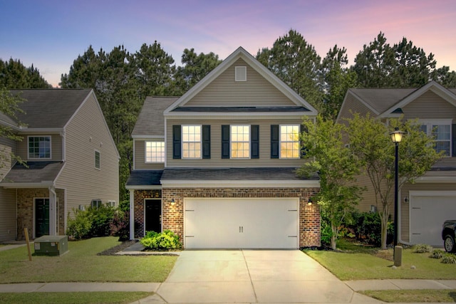 view of front of property with a lawn, roof with shingles, brick siding, an attached garage, and concrete driveway