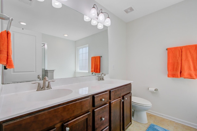 bathroom with a sink, toilet, double vanity, and tile patterned flooring